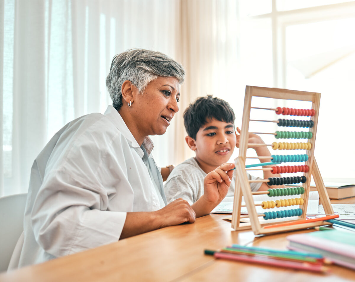 Education, autism and abacus with a grandmother teaching maths to her grandchild in the home for ch.