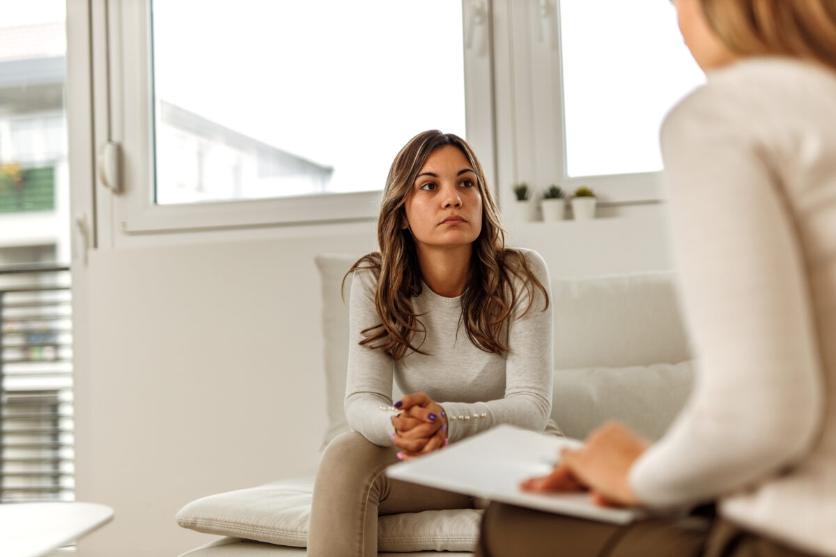 Young woman sitting on the therapist couch having a conversation