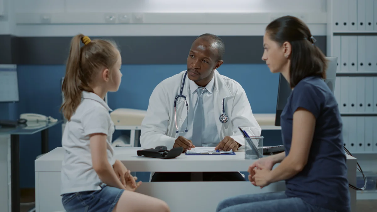 doctor talking to patients and taking notes on com